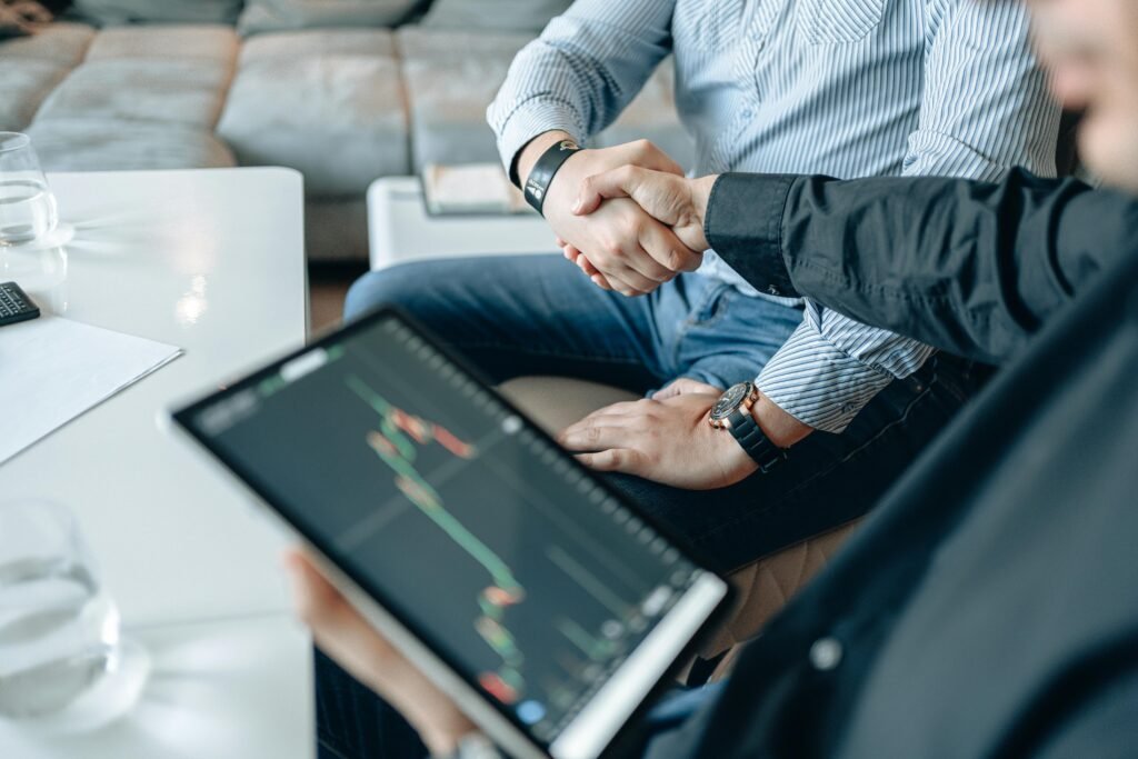 men shaking hands with a graph on a tablet