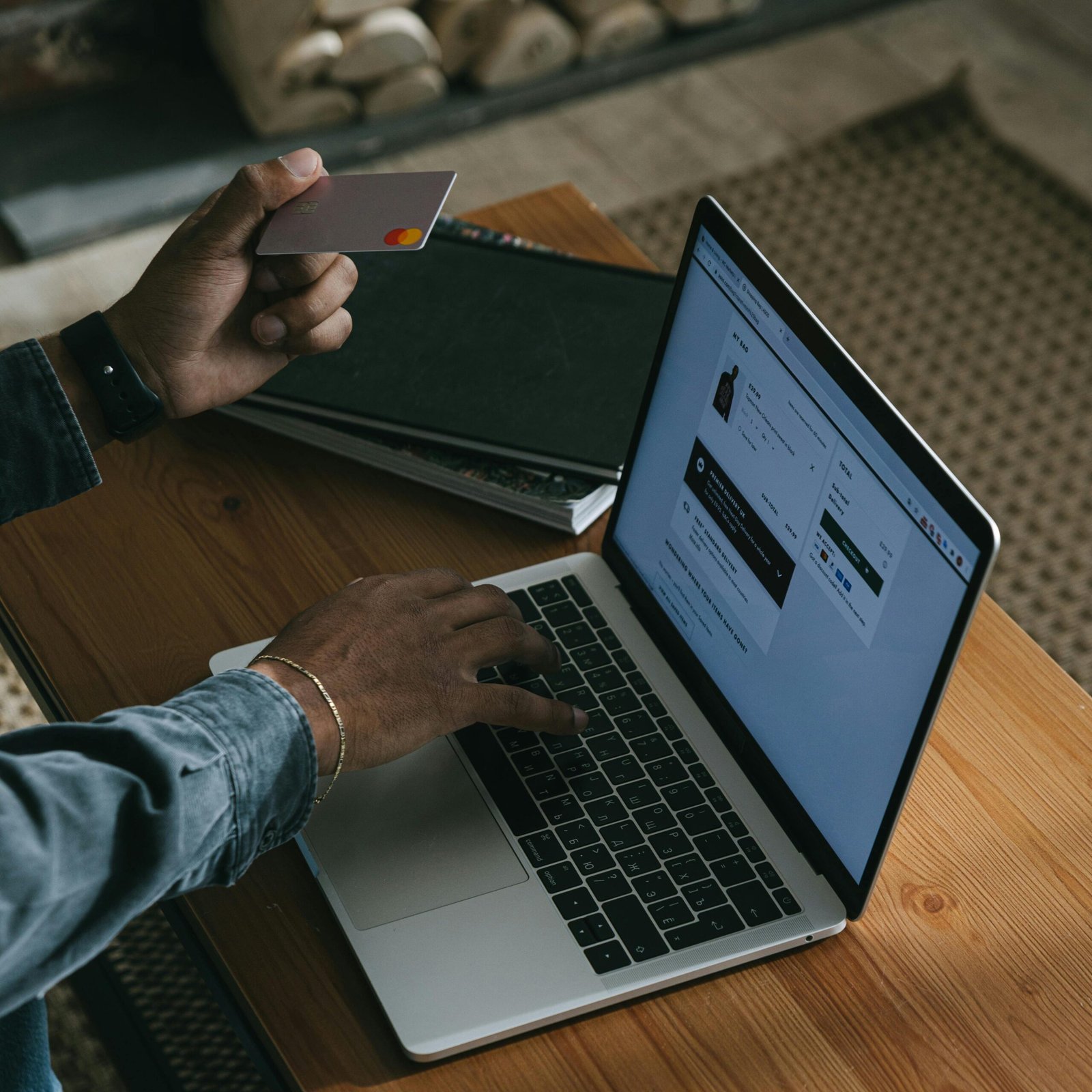 Person using a laptop for online shopping with a credit card in hand.